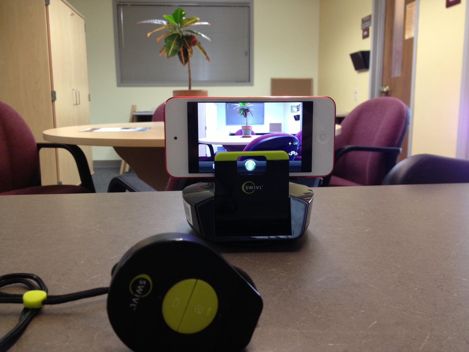 Swivl with iPod 5th generation. Remote (foreground) is worn by the presenter and has a built in microphone that integrates with your iDevice when the Swivl app is installed and the iDevice is plugged into the Swivl base. NOTE: Not compatible with all iDevices (see Media Services for details).
